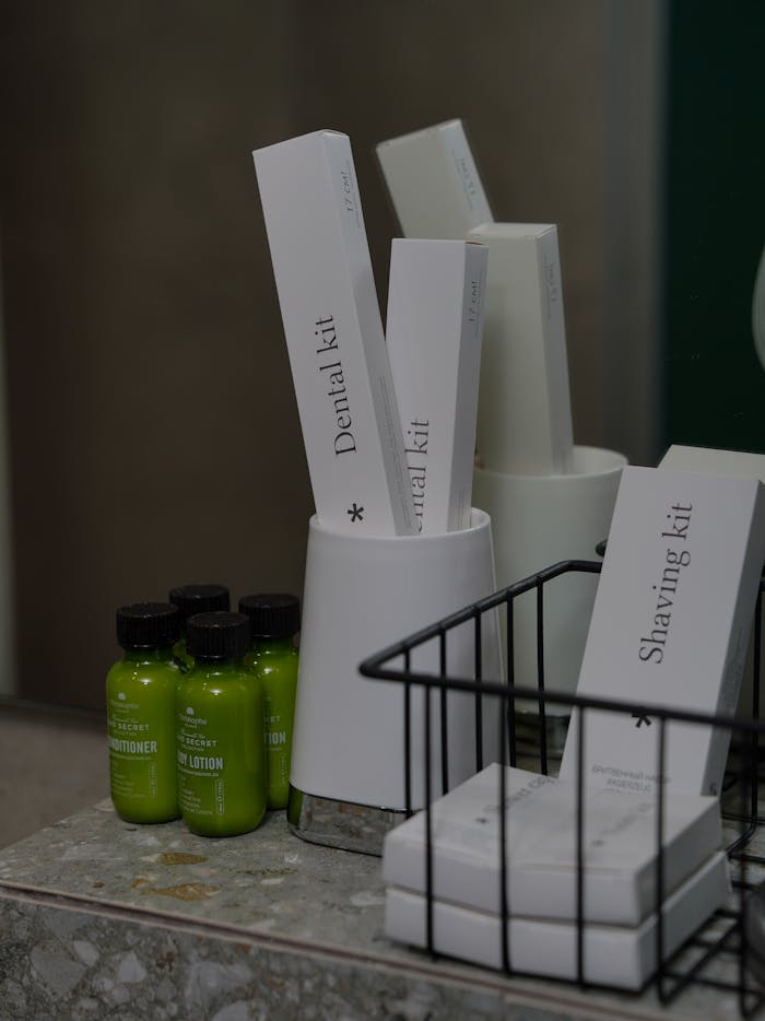 Close-up of hotel toiletries including dental and shaving kits on countertop.